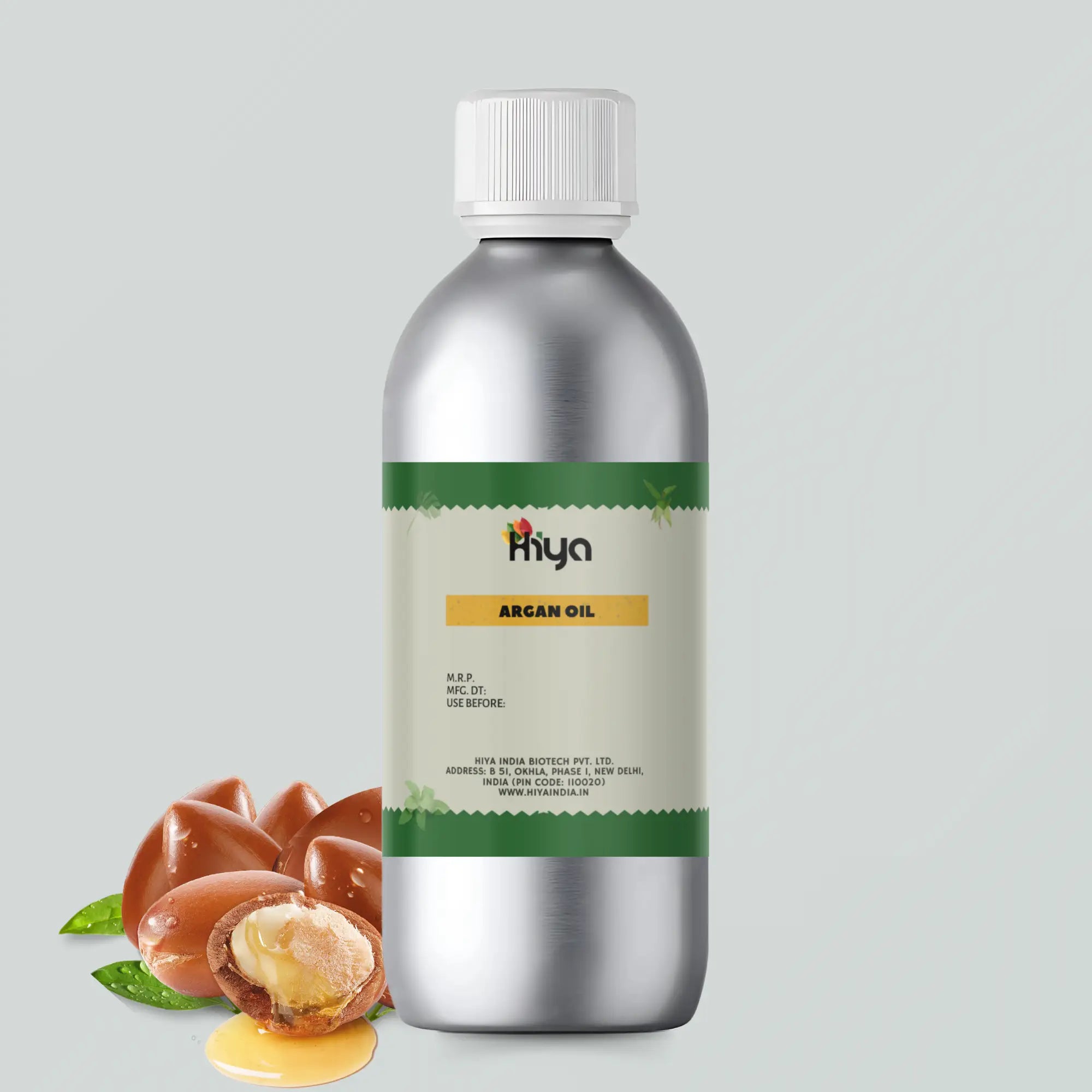 An Aluminum bottle filled with Argan oil and labeled as Hiya Argan Oil with a white cap. The label contains product details such as the brand name, manufacturing info, and the company website. In front of the bottle, there are Argan nuts and some oil, showcasing the natural ingredient of the product.