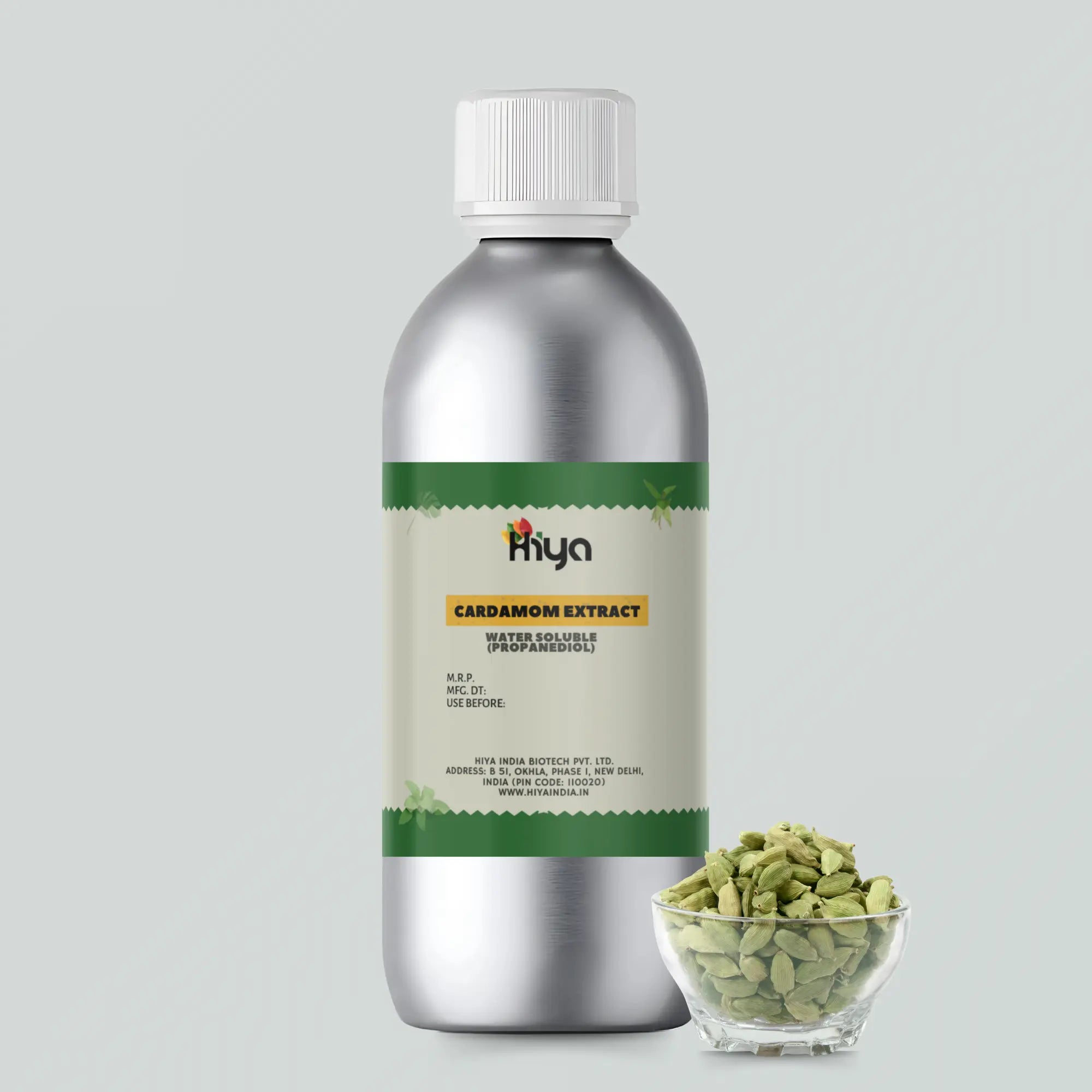 Hiya Cardamom Extract metallic bottle with a white cap. The bottle is displayed next to a glass bowl filled with cardamom pods.