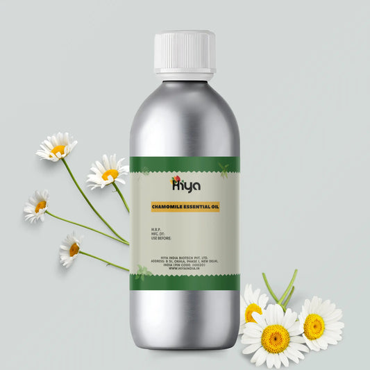 Hiya India Chamomile Essential Oil bottle with metallic finish and white cap, labeled "Chamomile Essential Oil." The bottle is surrounded by fresh chamomile flowers with white petals and yellow centers, symbolizing its organic and soothing properties.