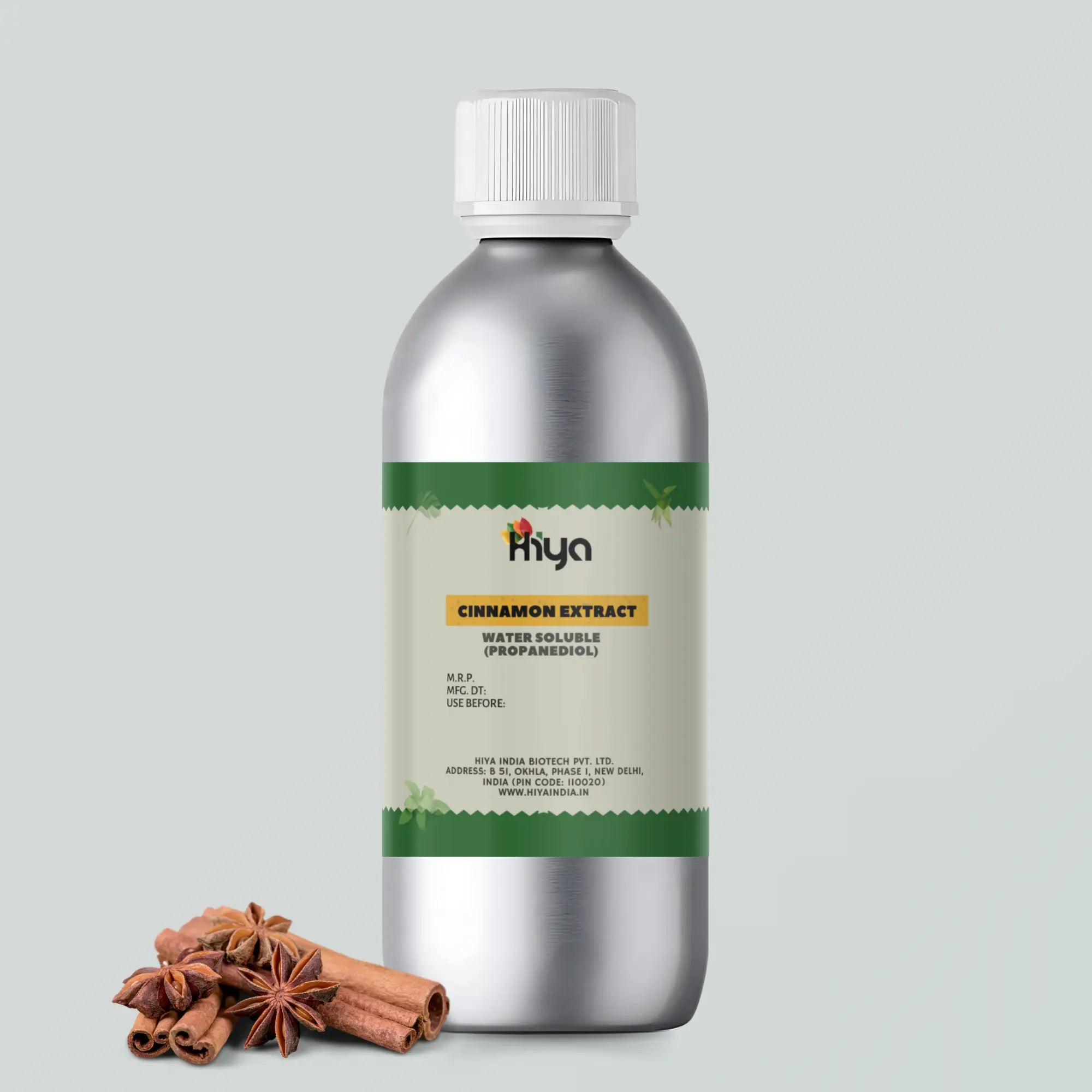 A silver bottle labeled "Hiya Cinnamon Extract Water Soluble" stands upright. Beside it, cinnamon sticks and star anise are placed.