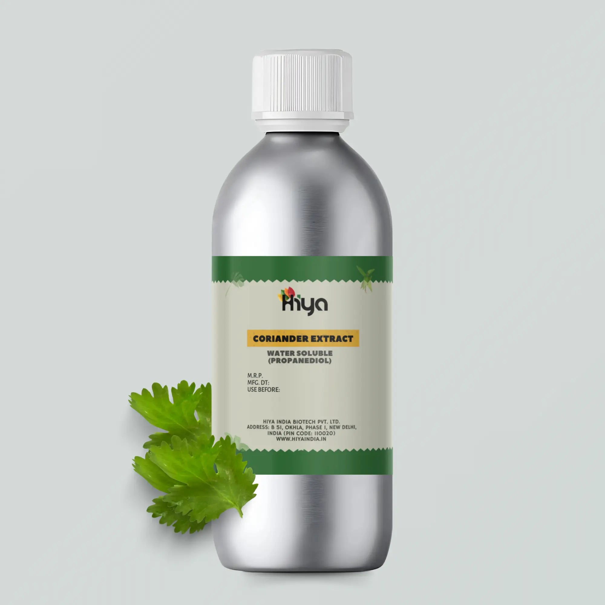A metallic bottle labeled "Hiya Coriander Extract Water Soluble (Propanediol)" stands upright. Beside the bottle, two fresh coriander leaves rest on the surface, representing the natural ingredient.