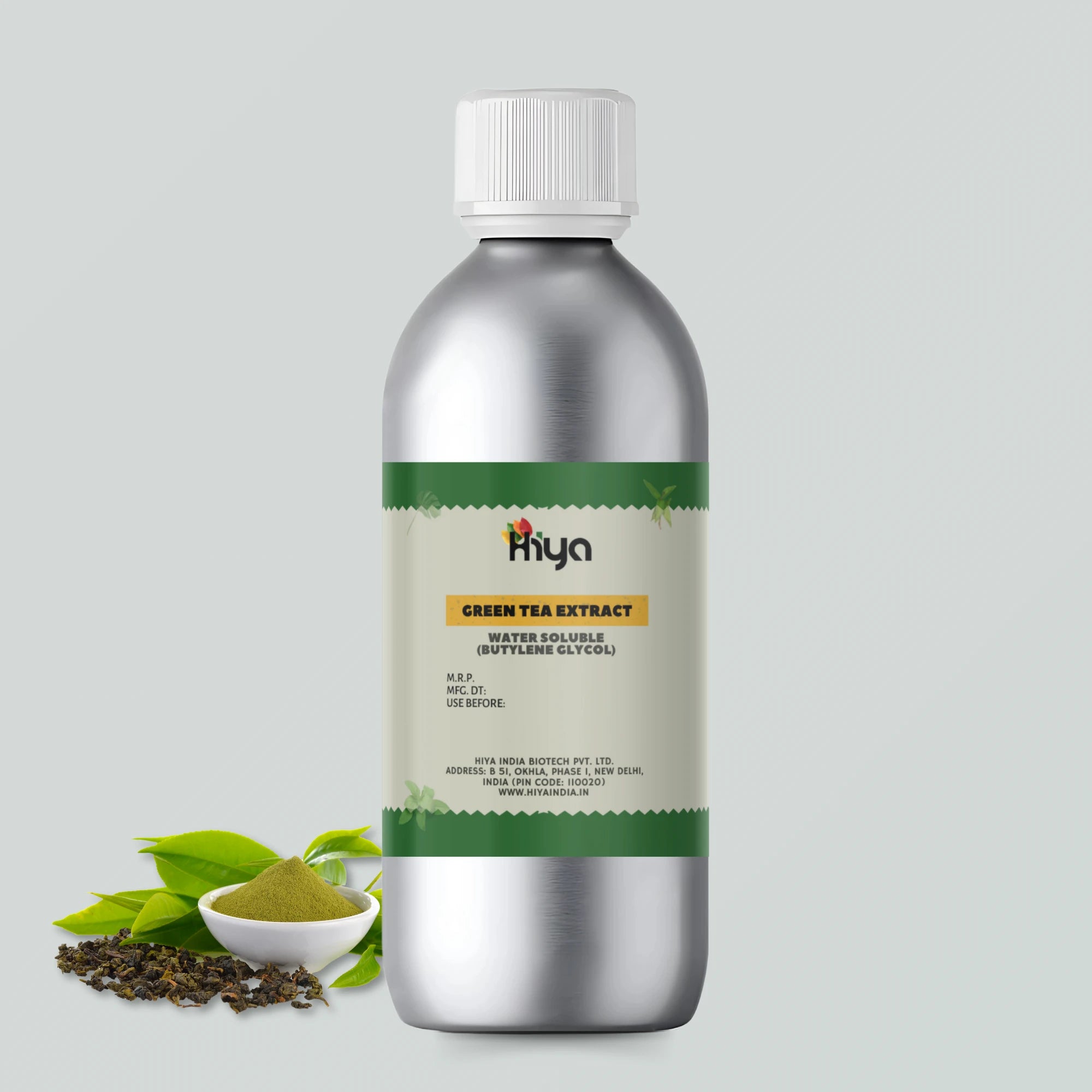 A metallic bottle labeled "Hiya Green Tea Extract Water Soluble (Butylene Glycol)" with a white cap. Beside the bottle, a small bowl of green tea powder and fresh green tea leaves emphasize the extract’s natural source.