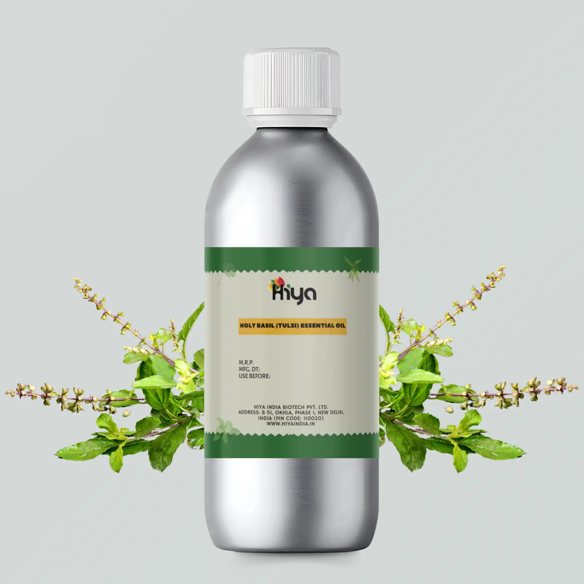 Hiya Holy Basil Essential Oil in a silver aluminum bottle with a green label, surrounded by fresh tulsi leaves, set against a light background.