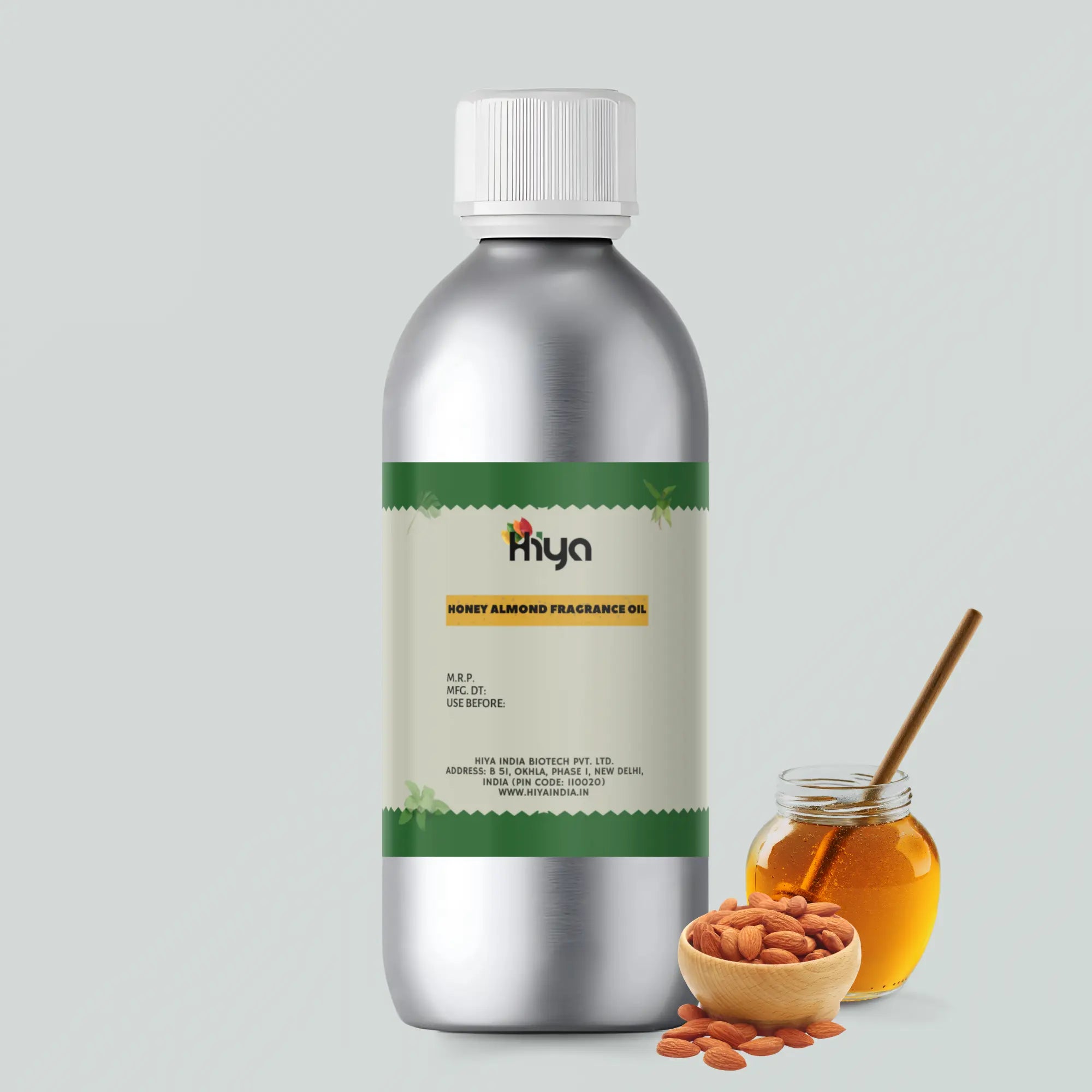 Hiya Honey Almond Fragrance Oil, displayed in a metallic bottle with white cap and green label, accompanied by fresh almonds in a bowl and a jar of honey with a honey dipper. Manufactured by Hiya India Biotech Pvt. Ltd., this fragrance oil emphasizes honey and almond scents for wellness and aromatherapy.