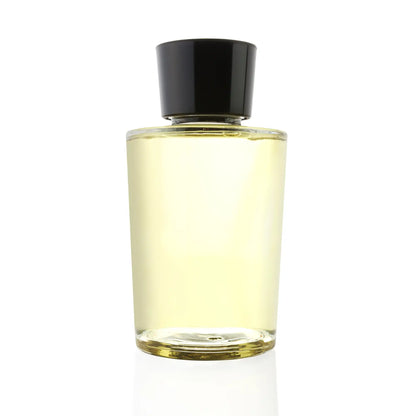A sleek, transparent glass bottle filled with a light golden-hued jasmine fragrance oil. The bottle features a minimalist design with a black cap, showcasing the purity and elegance of the aromatic oil inside by Hiya India.