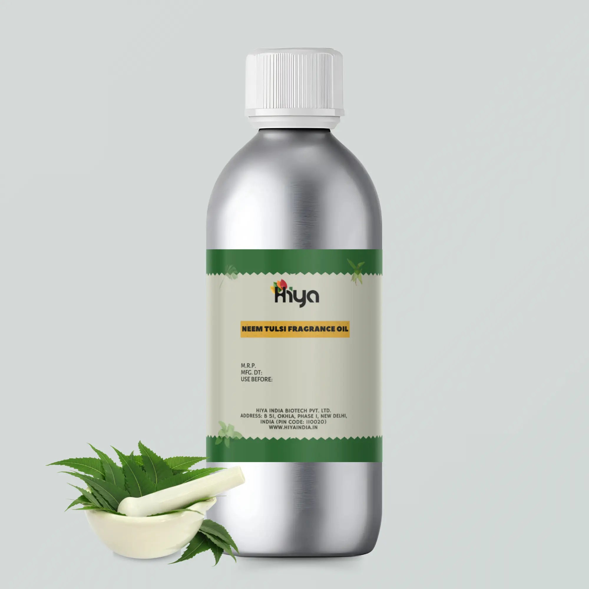 A metallic bottle labeled "Hiya Neem Tulsi Fragrance Oil" with product details like MRP, manufacturing date, and expiration date. The bottle is displayed alongside a small bowl containing fresh neem leaves and a piece of Tulsi stem.