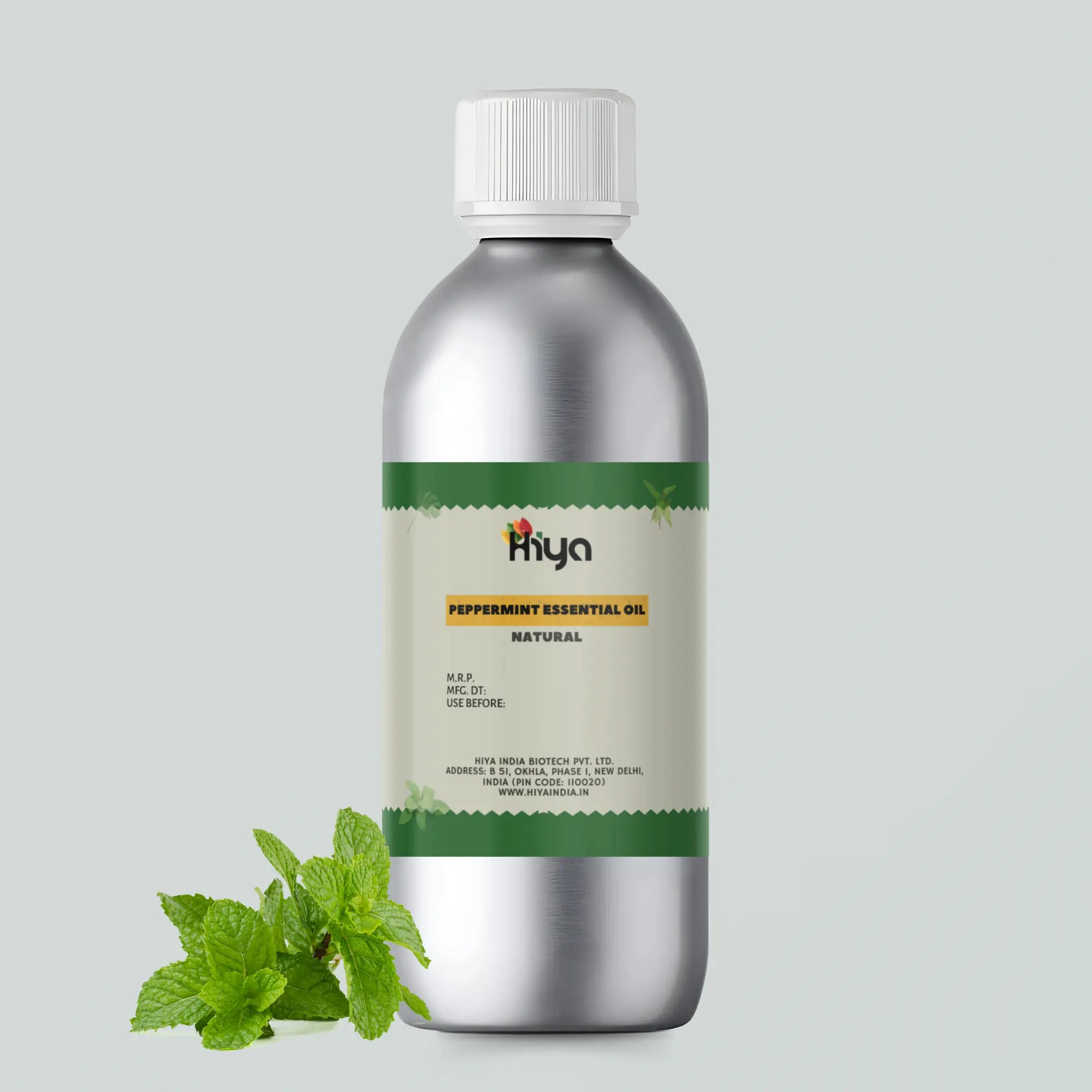 A bottle of Hiya India's Natural Peppermint Essential Oil sits next to fresh peppermint leaves. The setup is on a plain gray background.