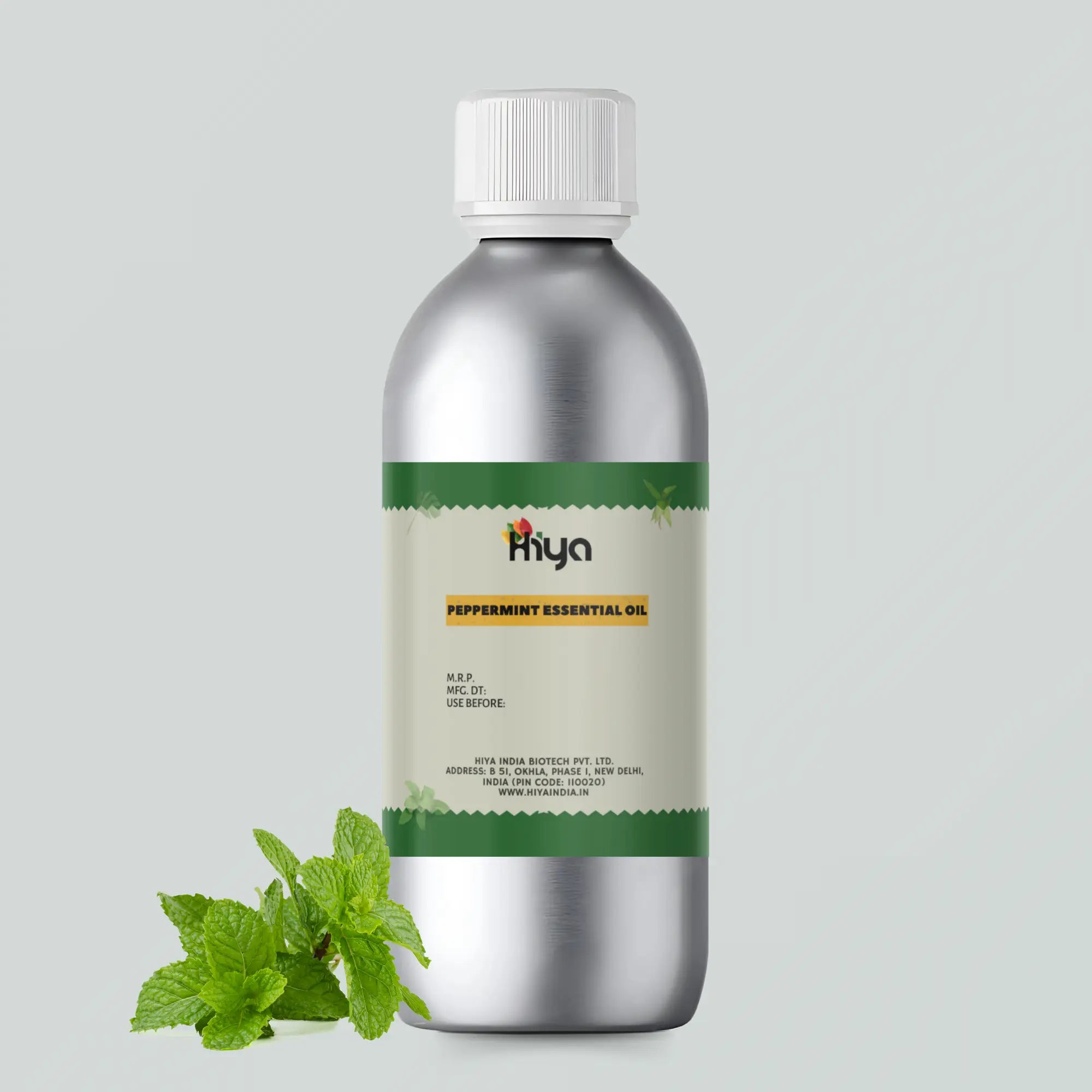 A metallic bottle labeled 'Hiya Peppermint Essential Oil' with a white cap sits next to fresh peppermint leaves. The setup is on a plain gray background.