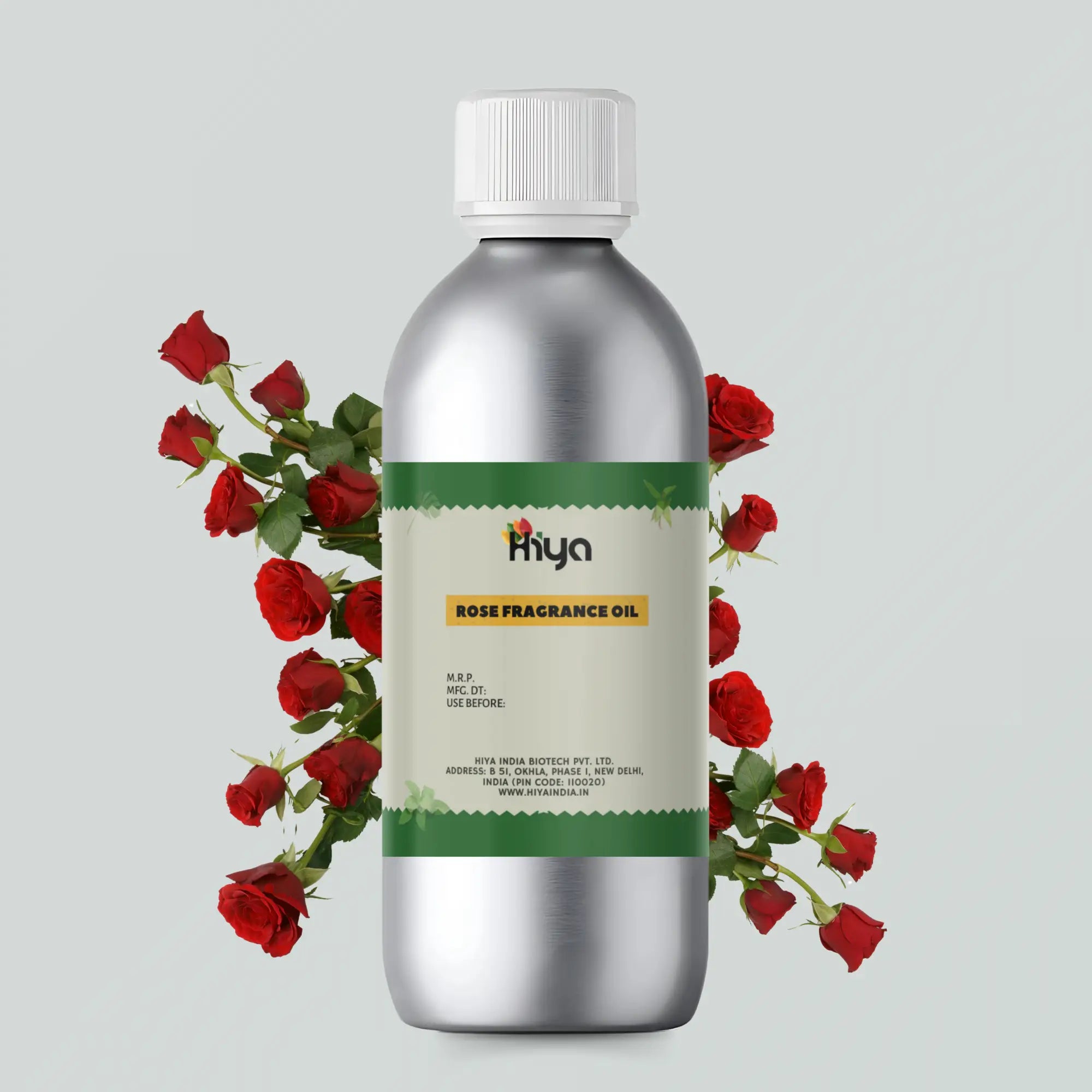 A metallic bottle labeled 'Hiya Rose Fragrance Oil' is surrounded by red roses. The label includes details like the product name, manufacturer information, and website. The bottle is placed on a light grey background with red roses adding a decorative touch.
