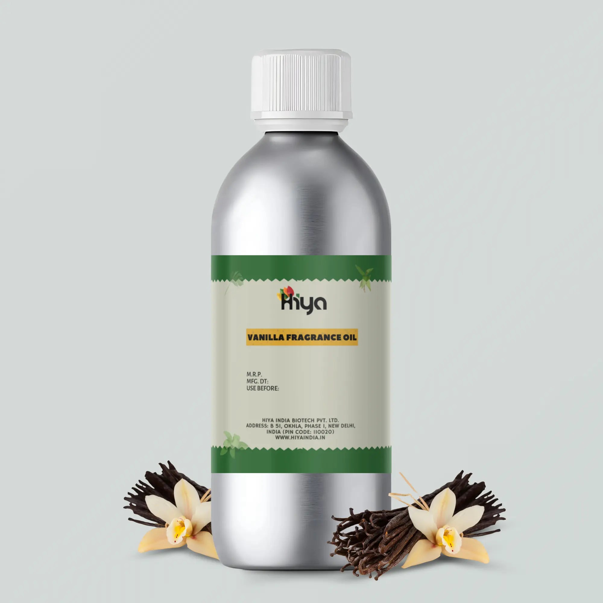 Hiya Vanilla Fragrance Oil in a metallic bottle with a white cap, displayed next to vanilla pods and white vanilla flowers. The product label mentions "Vanilla Fragrance Oil" and details like M.R.P., manufacturing date, expiration date, and the company name: Hiya India Biotech Pvt. Ltd., based in New Delhi, India.